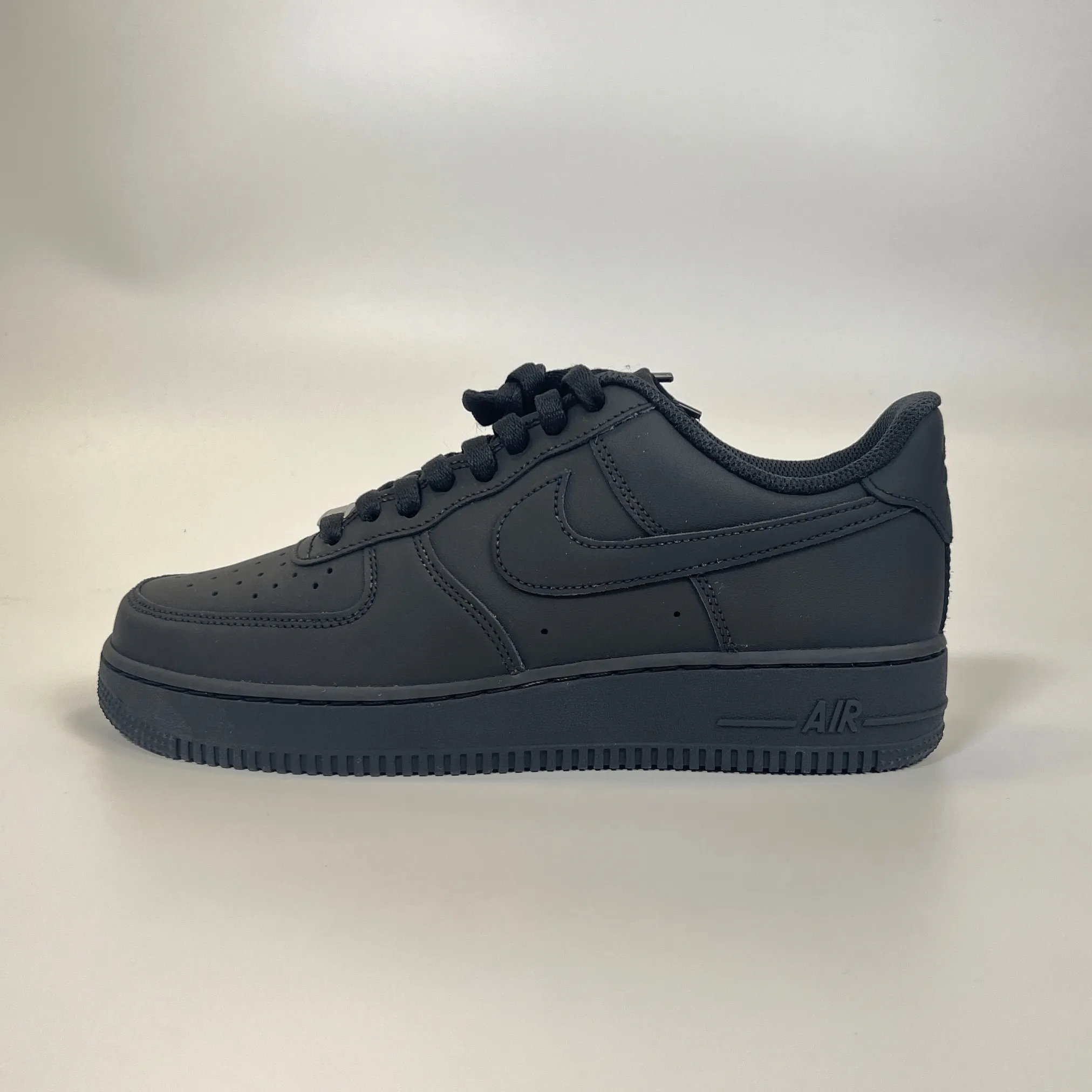 Nike Air Force 1 ??07 - Matte Black running with a gum rubber outsole daylight
